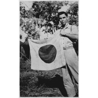 Lt. Woody J. Cochran holding a Japanese flag, New Guinea