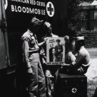 Three servicemen next to an American Red Cross Bloodmobile